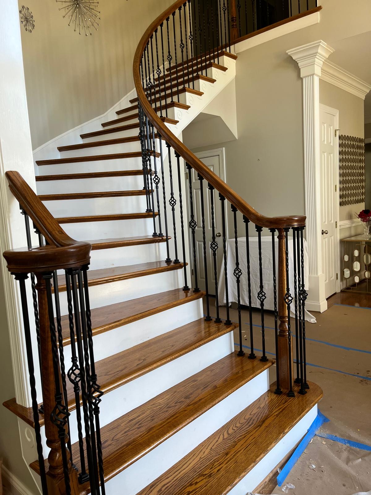 Refinished curved staircase with iron balusters